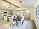 Open concept dining area with modern chandelier and adjacent kitchen at 7384 Van Lake Dr, Englewood, FL 34224