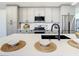 Modern kitchen with gray cabinets, quartz countertops and a large island at 7384 Van Lake Dr, Englewood, FL 34224