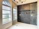 Large walk-in shower with a modern, textured tile wall at 7384 Van Lake Dr, Englewood, FL 34224