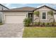 House exterior with a two-car garage and landscaping at 117 Runaway Field Ave, Nokomis, FL 34275