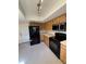 Kitchen features wood cabinets, black appliances, and tile floors at 2513 Lancaster Dr, Sun City Center, FL 33573