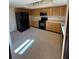 Kitchen features wood cabinets, black appliances, and tile floors at 2513 Lancaster Dr, Sun City Center, FL 33573