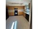 Kitchen features wood cabinets, black appliances, and tile floors at 2513 Lancaster Dr, Sun City Center, FL 33573