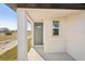 Front entrance with gray door and white columns at 120 Whiteland Bnd, Nokomis, FL 34275