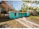 Neat teal house with a spacious yard and driveway at 7256 Pinehurst Dr, Spring Hill, FL 34606