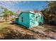Side view of teal house with a green lawn at 7256 Pinehurst Dr, Spring Hill, FL 34606