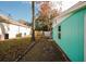Side yard view of teal house and fence at 7256 Pinehurst Dr, Spring Hill, FL 34606