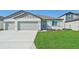 Newly constructed home with a two-car garage and well-manicured lawn at 13851 Richland Gulf Cir, Parrish, FL 34219