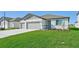 Two-car garage, light-grey exterior, and neatly landscaped front yard at 13851 Richland Gulf Cir, Parrish, FL 34219