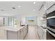 Modern kitchen with island, stainless steel appliances, and white cabinets at 13851 Richland Gulf Cir, Parrish, FL 34219