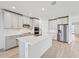 Modern kitchen with white cabinets, quartz countertops, and stainless steel appliances at 13851 Richland Gulf Cir, Parrish, FL 34219