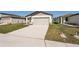 Front view of a house with a two-car garage and a well manicured lawn at 14036 Crutchfield Ct, Parrish, FL 34219