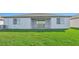 Rear view of house showing patio and grassy yard at 13855 Richland Gulf Cir, Parrish, FL 34219