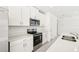 Modern kitchen with white cabinets, stainless steel appliances and island at 14037 Crutchfield Ct, Parrish, FL 34219