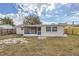 Home's backyard with screened porch and fenced yard at 3531 Oxford Dr, Holiday, FL 34691