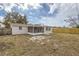 Home's backyard with screened porch and fenced yard at 3531 Oxford Dr, Holiday, FL 34691