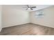 Simple bedroom with ceiling fan and wood-look flooring at 3531 Oxford Dr, Holiday, FL 34691