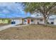 Tan house with red door, driveway, and landscaping at 3531 Oxford Dr, Holiday, FL 34691