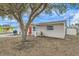 Tan house with red door and large tree in front at 3531 Oxford Dr, Holiday, FL 34691