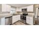 Updated kitchen with white cabinets, granite counters, and stainless steel appliances at 3531 Oxford Dr, Holiday, FL 34691