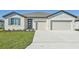 Two-story house with light-colored siding, gray shutters, and a two-car garage at 13859 Richland Gulf Cir, Parrish, FL 34219