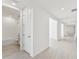 Bright hallway with light wood-look tile flooring and access to a bathroom at 13859 Richland Gulf Cir, Parrish, FL 34219