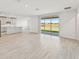 Open concept living room and kitchen with light wood-look tile flooring at 13859 Richland Gulf Cir, Parrish, FL 34219