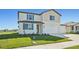 Two-story house with beige siding, blue shutters, and a three-car garage at 13868 Richland Gulf Cir, Parrish, FL 34219