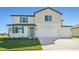 Two-story house with a two-car garage and teal accents at 13868 Richland Gulf Cir, Parrish, FL 34219