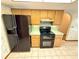 Kitchen features wood cabinets, black appliances and a breakfast nook at 12010 Villa Rd, Spring Hill, FL 34609