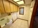 Laundry room with wood cabinets and a utility sink at 12010 Villa Rd, Spring Hill, FL 34609