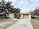 Single-story house, beige exterior, attached garage, needs cosmetic updates at 4935 Mockingbird Dr, Dade City, FL 33523