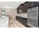 Bright kitchen featuring stainless steel appliances, granite countertop, and dark cabinets at 33161 Kateland Dr, Wesley Chapel, FL 33545