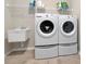 Clean laundry room with washer, dryer, utility sink, and storage shelf at 33161 Kateland Dr, Wesley Chapel, FL 33545