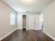 Bright bedroom with dark brown wood-look flooring, closet, and two doors at 4675 20Th S Ave, St Petersburg, FL 33711