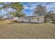 Large backyard with a view of the home's back elevation and a wooden fence at 5405 Mariner Blvd, Spring Hill, FL 34609