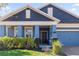Two-story home with blue exterior, landscaping, and a dark brown door at 1570 Fox Grape Loop, Lutz, FL 33558