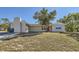 Ranch-style home with a red door, well-maintained lawn, and mature trees at 6256 Kimball Ct, Spring Hill, FL 34606
