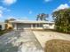 Ranch style home with a large driveway and mature landscaping at 11397 86Th Ave, Seminole, FL 33772