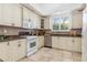 White kitchen features ample cabinetry, granite countertops, and stainless steel appliances at 818 Via Tripoli, Punta Gorda, FL 33950