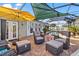 Covered patio with wicker furniture, umbrella, and red accent table at 4086 Gardner Dr, Port Charlotte, FL 33952