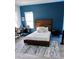 Serene bedroom with a wooden bed frame and blue accent wall at 811 Manns Harbor Dr, Apollo Beach, FL 33572
