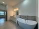Bright bathroom has a stand alone tub with double sinks and tile flooring at 135 Sunset Rd, Rotonda West, FL 33947