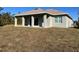 Single-story house with covered patio and grassy yard at 135 Sunset Rd, Rotonda West, FL 33947