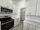 Well-equipped kitchen with stainless steel appliances, modern lighting, and ample counter space at 135 Sunset Rd, Rotonda West, FL 33947