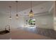 Open living space with views of the backyard through sliding glass doors and modern pendant lighting at 135 Sunset Rd, Rotonda West, FL 33947