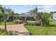 Single-story home with a large front porch, landscaping, and brick driveway at 505 Sally Lee Dr, Ellenton, FL 34222
