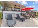 Spacious patio with lounge chairs, table and red umbrella at 505 Sally Lee Dr, Ellenton, FL 34222
