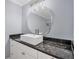 Modern bathroom with a white sink, dark countertop, and round mirror at 8115 61St N St, Pinellas Park, FL 33781