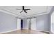 Spacious bedroom with tile flooring, ceiling fan, and barn doors at 8115 61St N St, Pinellas Park, FL 33781